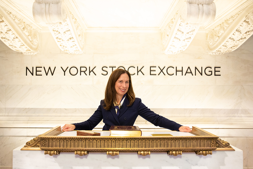 Lisa Alexander standing behind the NYSE lectern in NYC