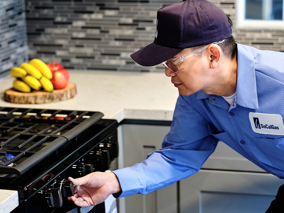 a SoCalGas employee inspecting a gas stove