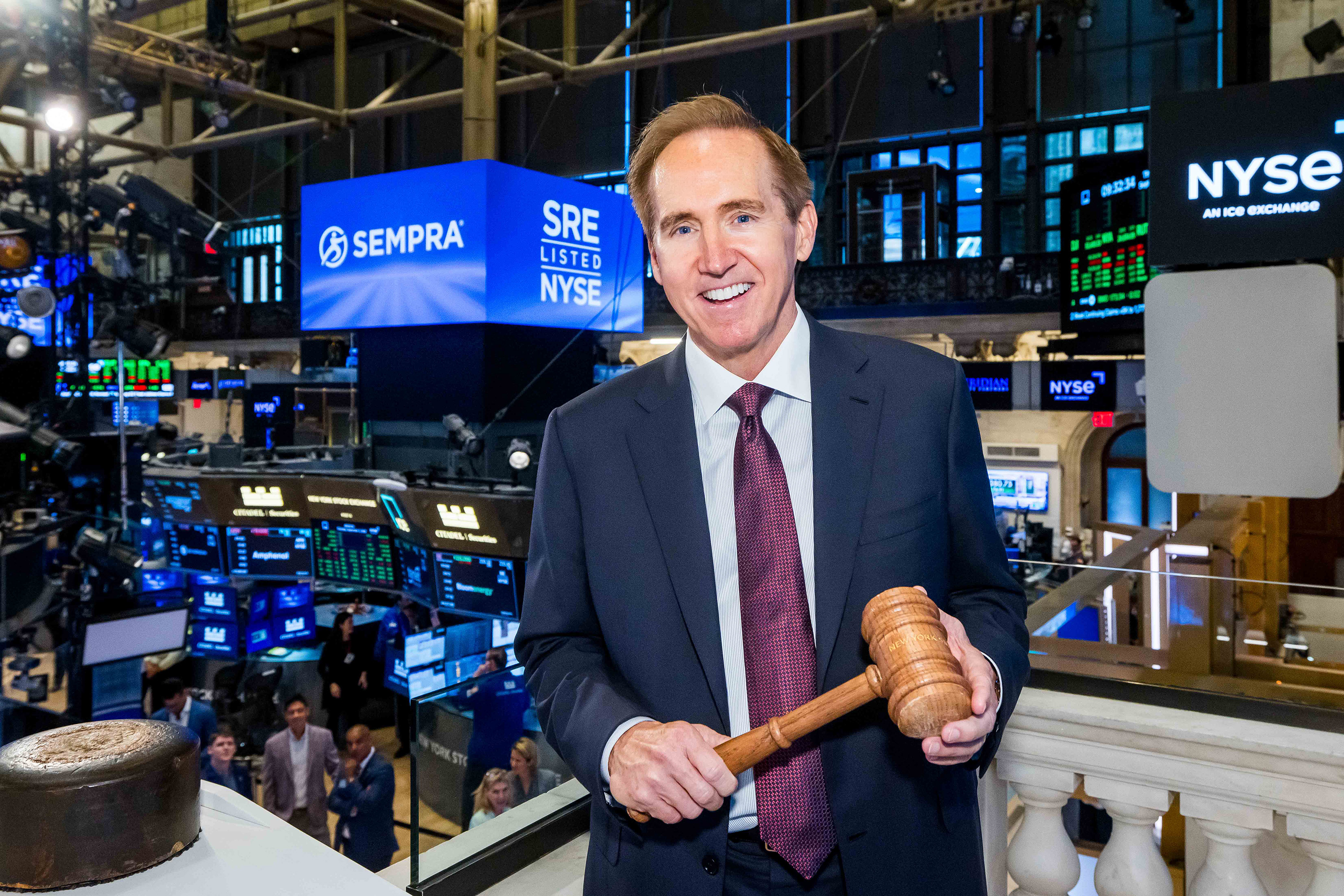 Jeffrey W. Martin, Chairman and CEO of Sempra holding a bell-ringing gavel.